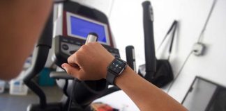 Apple Watch at the gym with Now Playing music on screen