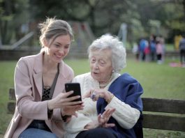 daughter and senior looking at phone together