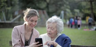 daughter and senior looking at phone together